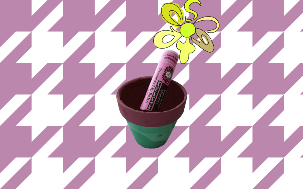 a purple/white houndstooth background holds a small, painted green teracotta pot. a pink lip balm tube that reads "biodegradable" sits inside the plant pot