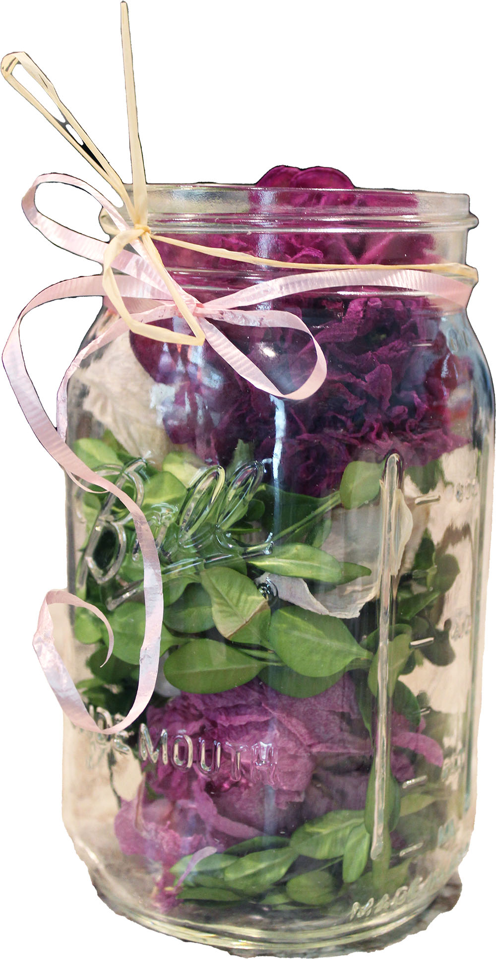 a mason jar contains boxwood stems and dried peonies