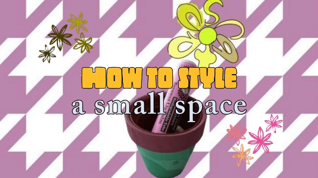 a patterned purple houndstooth background holds a small, terracotta pot painted green holding a disposable lip balm that looks the same as a regular one but it says "Biodegradable Tube". the flavor is juicy blackberry and a catsup logo that looks like a green flower is placed so as to "bloom" from the end of the lip balm tube "how to style a small space" breathes as a gif