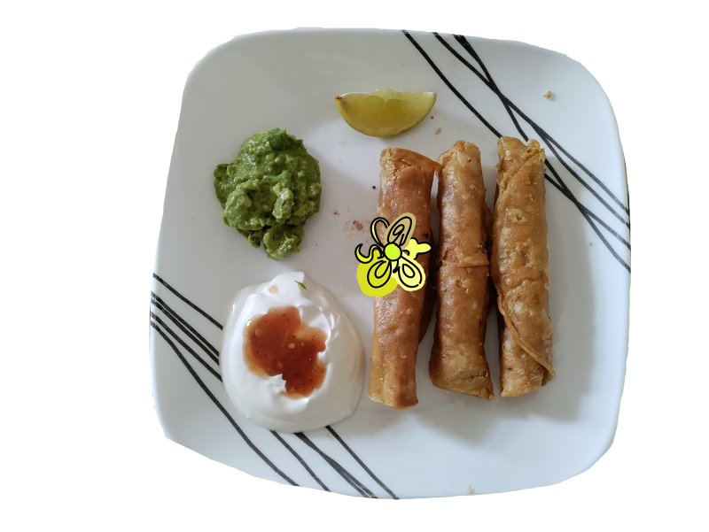 Golden taquitos better known as flautas in the Mexican American community are served next to sour cream and red salsa, and smashed avocado spread.
