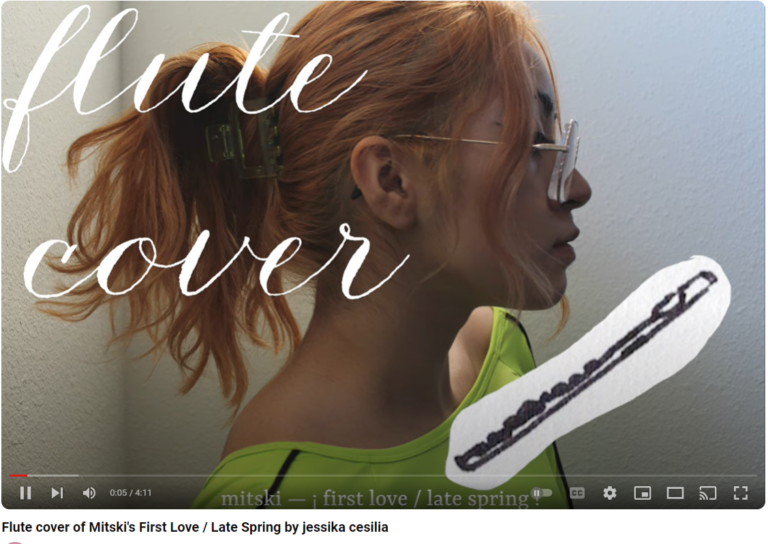 A YouTube video's thumbnail shows a person's profile with their wavy, reddish medium-length hair being pulled up into a hair tail. Long anime bangs make for a signature profile. Angular shoulders are covered with a lime green athletic long sleeve shirt. Flute cover is written in large, fancy script on the top left corner. A flute doodle has been collaged in front of the individual's lips, as if blowing into the flute from a distance.